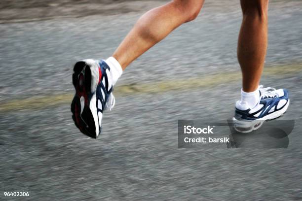 Feet Of A Running Woman On Asphalt Next To Faded Yellow Line Stock Photo - Download Image Now