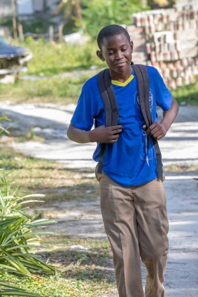 ragazzo giamaicano in età scolare che cammina a scuola - high schooler foto e immagini stock