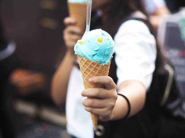 girl holding and giving ice cream