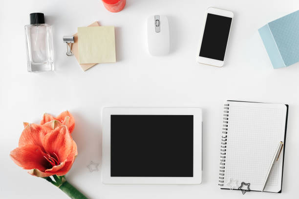 istock Flat lay, top view office table desk. Feminine desk workspace with flower amaryllis, tablet, notebook with pen, smartphone, computer mouse and female perfume 964047860