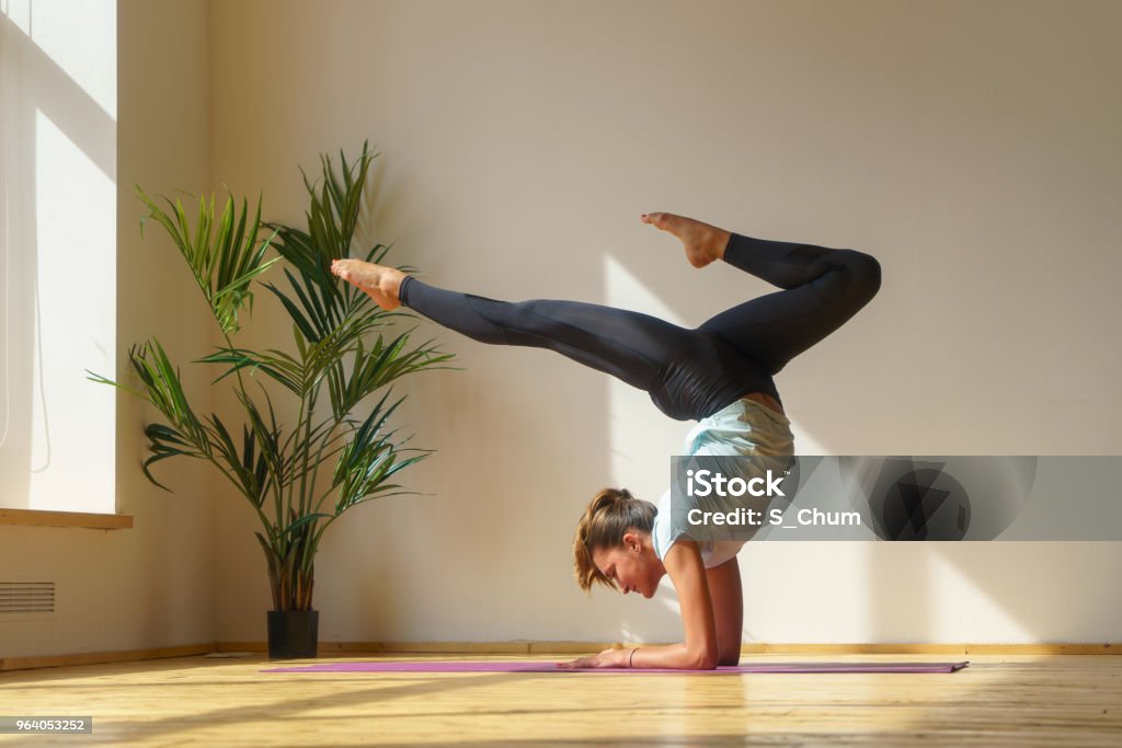 young fit woman doing stretching exercise young flexible woman handstand and doing gymnastic exercise at home, natural light Handstand Stock Photo