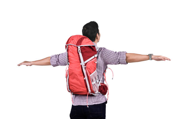 Rear view of asian traveler with backpack standing isolated over white background