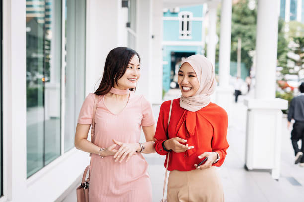 istock Two friends in Asia walking down the street 964070812