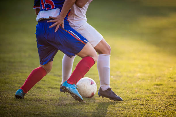 istock Unrecognizable female soccer player keeping the ball safe from her rival on a match. 964084914