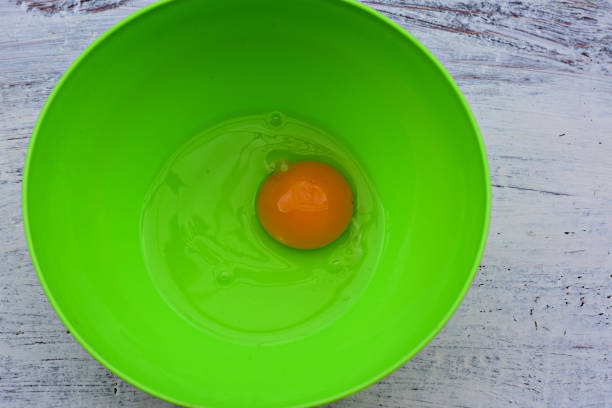 istock Fresh raw egg yolk and white whit salt at green bowl / Food background/ Flatware 964085156