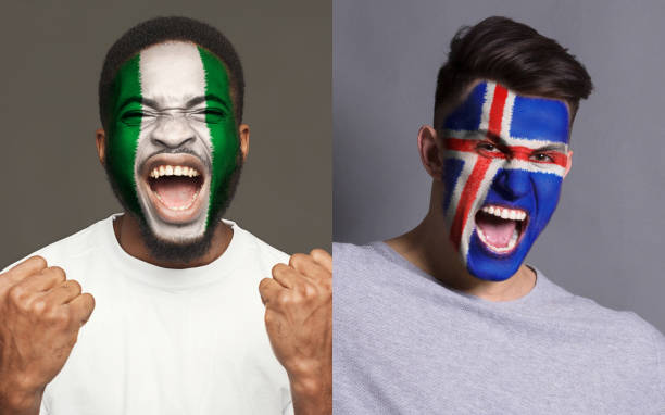 istock Emotional soccer fans with painted flags on faces 964088374