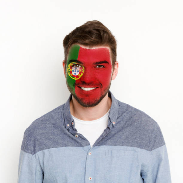 istock Young man with Portugal flag painted on his face 964088492