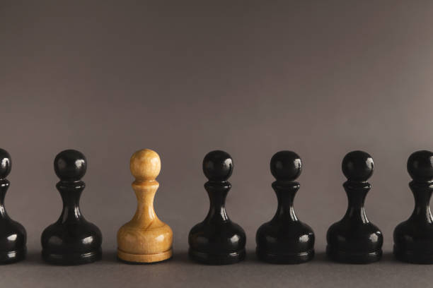 istock Line of black pawns with one white inside 964091592
