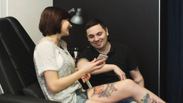 istock Man and woman choosing tattoo design in studio 964091952