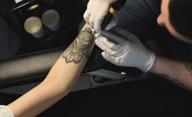 istock Professional tattoo artist making tattoo on hand 964092090