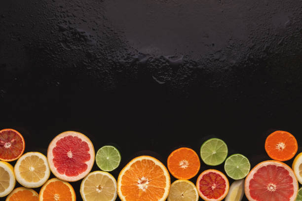 istock Variety of ripe citruses on black background 964094260