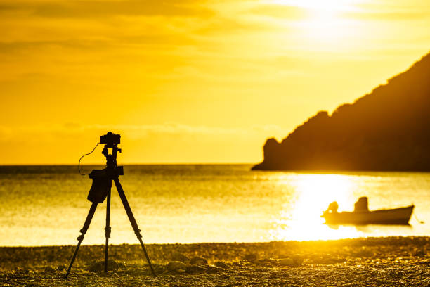 istock Camera taking picture of sunrise over sea surface 964095426