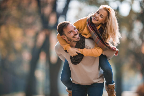 istock Cheerful couple having fun while piggybacking in autumn. 964102320