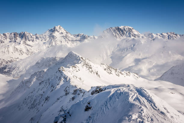 Scenery from the summit of a mountain in the alps of Switzerland, the surrounding peaks and glaciers are all covered in snow during the winter season