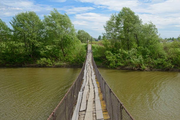 old suspension bridge across the river on a summer sunny day