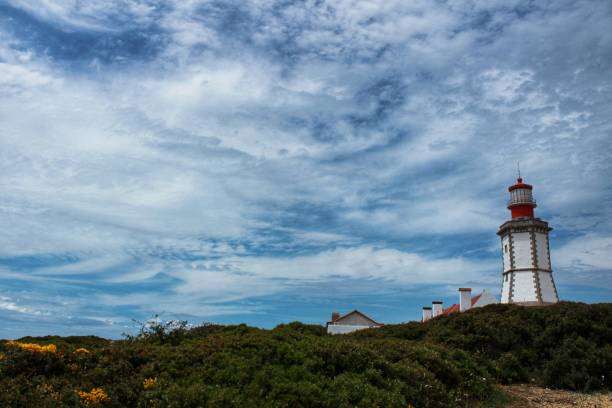 istock Lighthouse on top of cliff and surrounded by vegetation at Cape Espichel 964109784