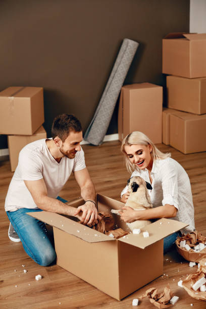 istock Couple With Dog And Boxes Moving In New Apartment 964112638
