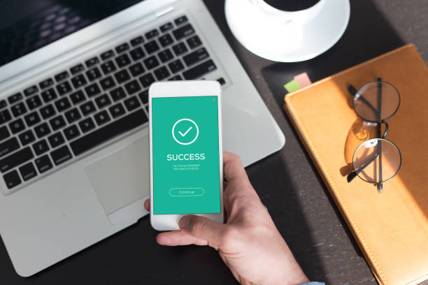 istock Hand holding smartphone and showing success screen 964119410