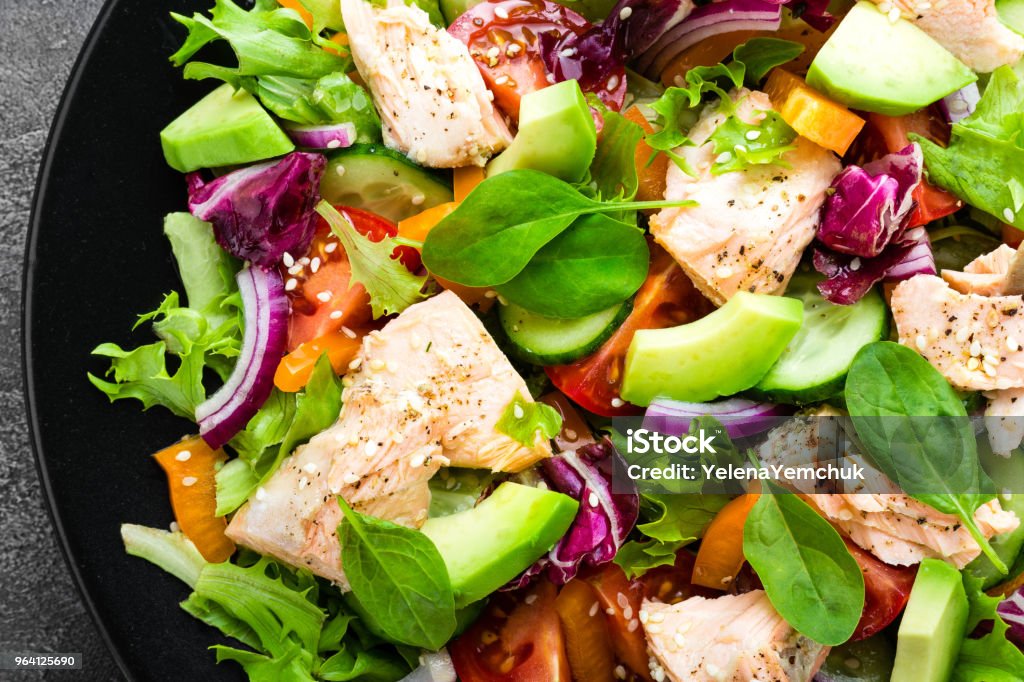 Salad with fish. Fresh vegetable salad with salmon fish fillet. Fish salad with salmon fillet and fresh vegetables on plate Healthy Eating Stock Photo