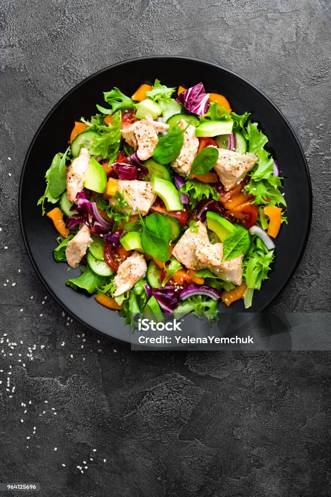 Salad with fish. Fresh vegetable salad with salmon fish fillet. Fish salad with salmon fillet and fresh vegetables on plate Above Stock Photo