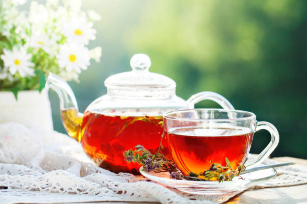 istock Cup with hot tea with mint and a thyme on a wooden table in a summer garden. Selective focus, Background with copy space 964129002
