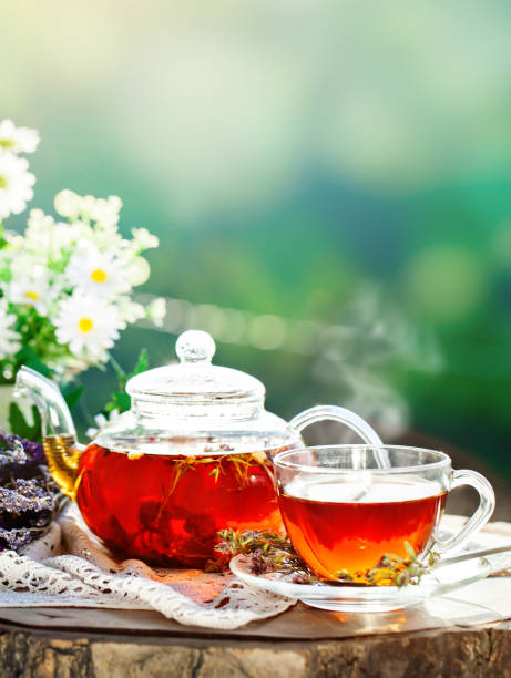 istock Cup with hot tea with mint and a thyme on a wooden table in a summer garden. Selective focus, Background with copy space 964129050