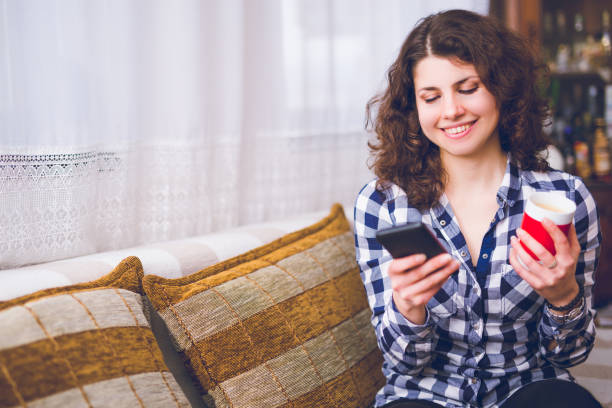 istock Woman relaxing with cup of coffee and using mobile phone. 964132110
