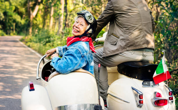 Senior couple riding a classic scooter