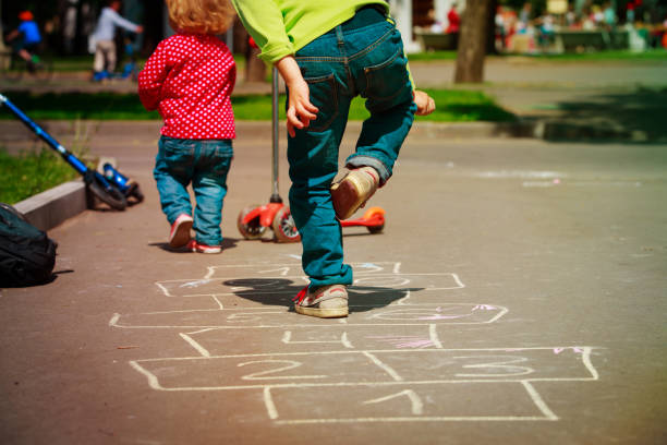 istock kids playing hopscotch on playground 964143892
