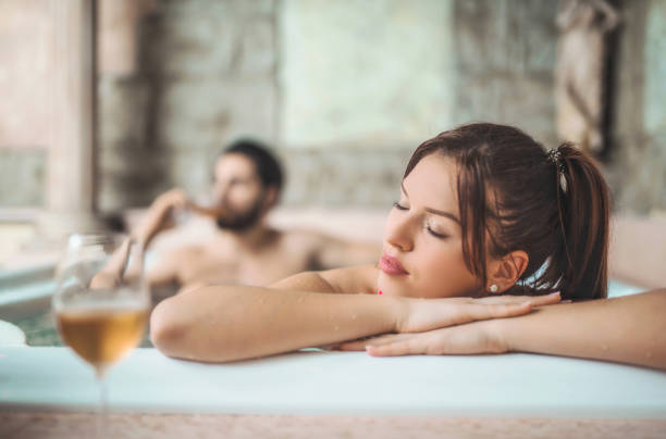 piękna młoda kobieta relaks w wannie z mężem. - couple hot tub spa treatment health spa zdjęcia i obrazy z banku zdjęć