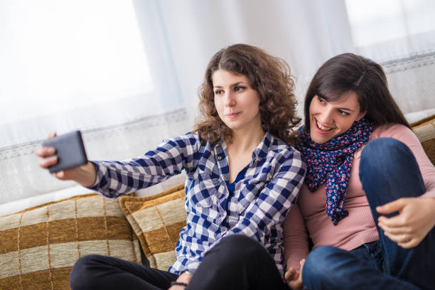 istock Two woman sitting on bed and make selfie. 964151212