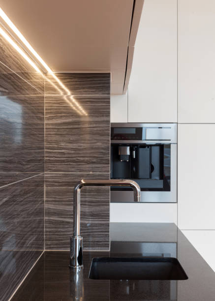 istock New modern kitchen with built in oven and chrome water tap. LED worktop illumination 964155206