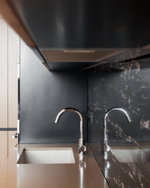 istock Detail of a rectangular designer kitchen sink with chrome water tap against a tiled wall 964155312