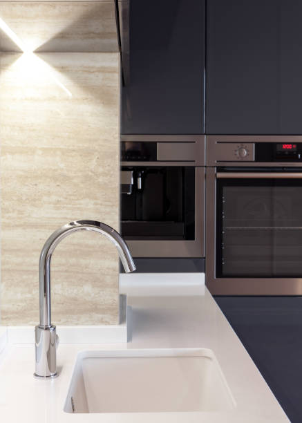 istock New modern kitchen with built in oven and chrome water tap. LED worktop illumination 964155350