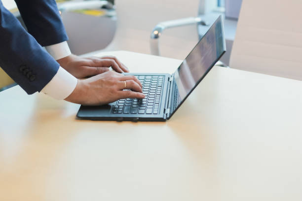 istock male office worker suit laptop window desk 964155464