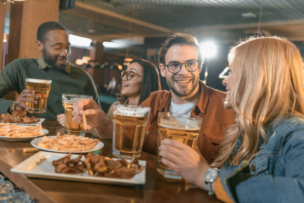 istock attractive multiculture friends eating and drinking at bar 964155510