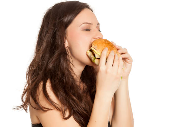 istock young beautiful greedy woman eating a hamburger on white background 964155952