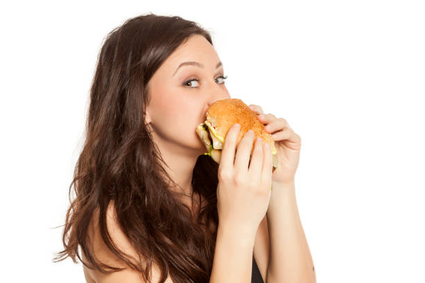 istock young beautiful greedy woman eating a hamburger on white background 964155960