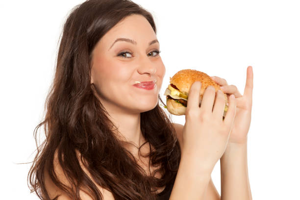 istock young stuffed greedy woman eating a hamburger on white background 964155982