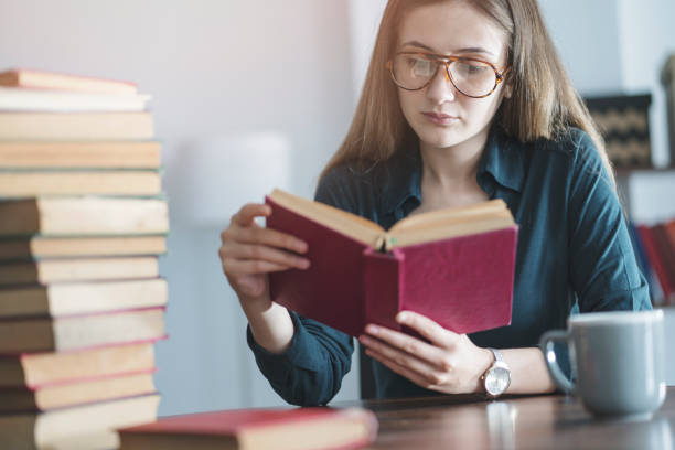 istock Young girl reading book on the table 964156034