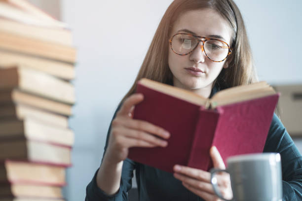 istock Young girl reading book on the table 964156036