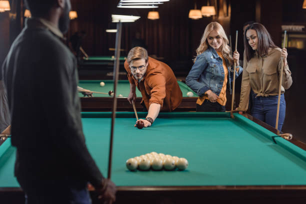 istock young multiethnic friends playing in pool at bar 964159090