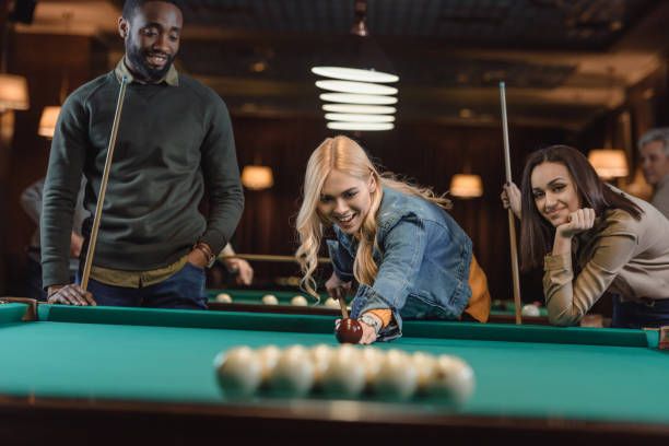 istock young multiethnic friends playing in pool at bar 964159252
