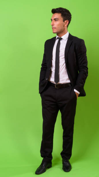 istock Young handsome Hispanic businessman against green background 964159352