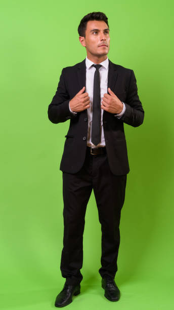 istock Young handsome Hispanic businessman against green background 964159388