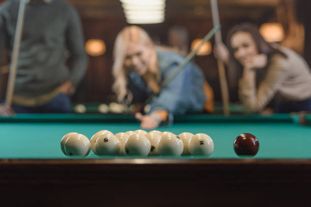 istock young multiethnic friends playing in pool at bar 964159620
