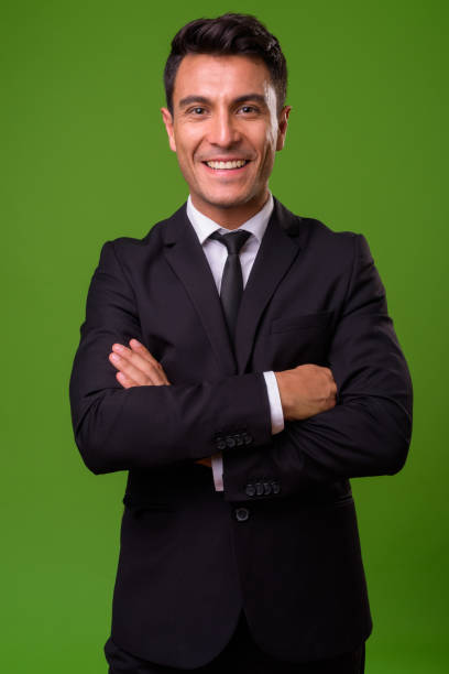 istock Young handsome Hispanic businessman against green background 964159824