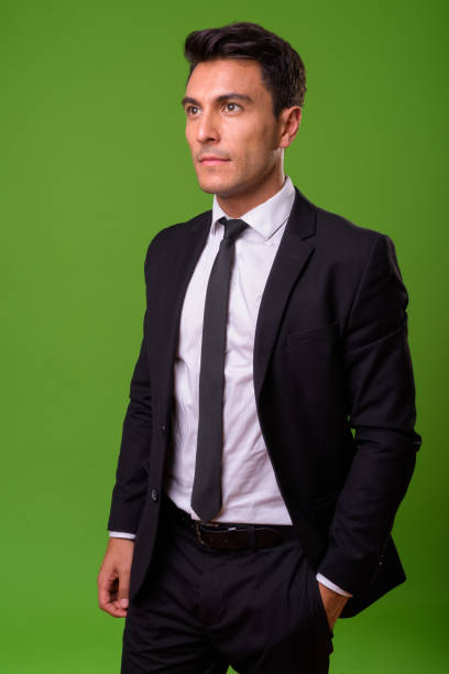 istock Young handsome Hispanic businessman against green background 964159884