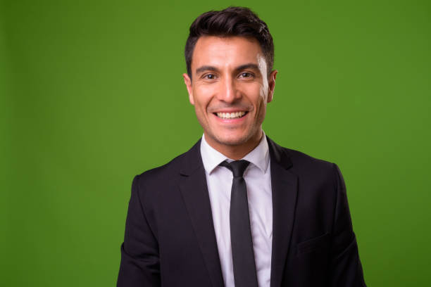 istock Young handsome Hispanic businessman against green background 964160100
