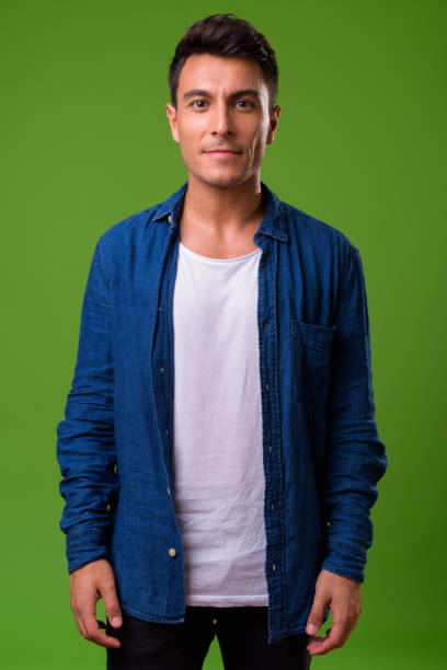 istock Young handsome Hispanic man against green background 964162244